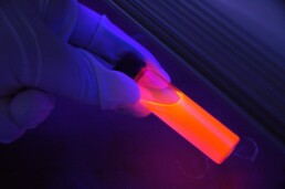 Tubo de ensayo con contenido líquido visto con luz fluorescente