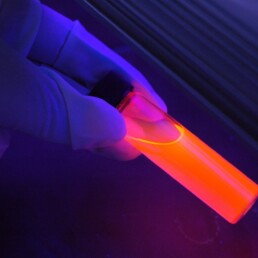 Tubo de ensayo con contenido líquido visto con luz fluorescente
